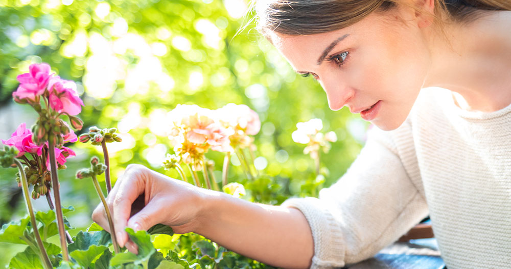 woman checking underside of plants